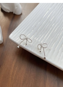Detail of S925 silver bow earrings with twisted rope texture and small silver beads