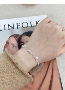 Detailed view of S925 sterling silver bracelet with croissant charms on a wrist
