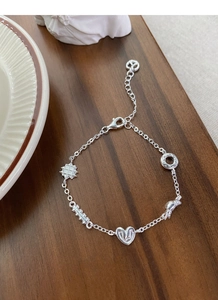 Detailed macro view of S925 silver bracelet featuring heart, donut and rabbit charms