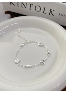 Detail showing S925 silver bracelet charms with heart, waffle, donut and croissant shapes