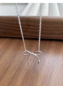 Detail view of S925 silver bow pendant necklace with textured stripes on O-chain link