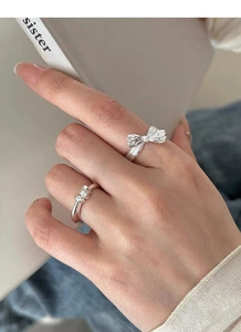 Detailed view of S925 sterling silver bow and twisted ring set on female hand