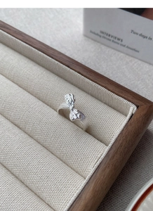 Detail of S925 sterling silver bow ring with textured finish in a velvet jewelry box