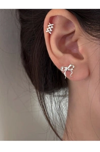 Close-up of S925 sterling silver ribbon bow stud earrings and crisscross ear cuff on model