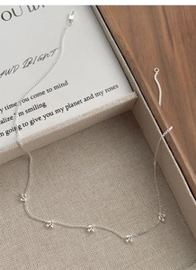 Detailed close-up of a sweet S925 sterling silver cherry pendant necklace on a beige tray