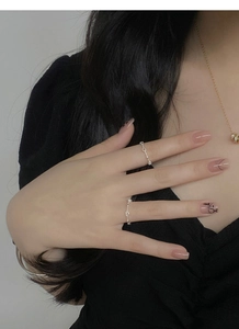 Close-up of minimalist S925 sterling silver hollow heart ring on finger with nail art
