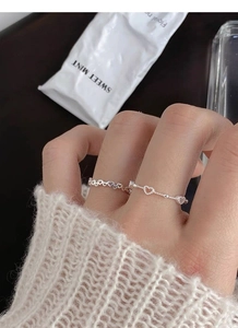 Close-up of minimalist S925 sterling silver hollow heart rings on a model's hand
