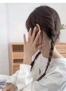 Detail of adjustable hollow heart silver rings worn on model fingers for elegant look