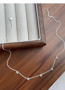Macro detail of S925 sterling silver cherry pendant necklace on wooden tray