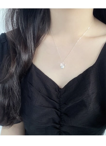 Élégant collier en argent S925 avec nœud et pendentif perle sur le cou d'un mannequin