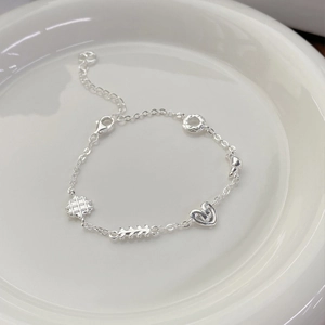 S925 sterling silver bracelet with croissant and waffle charms on white ceramic plate