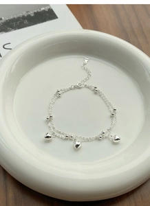 Macro shot of S925 sterling silver double-layer bracelet with heart charms and beads