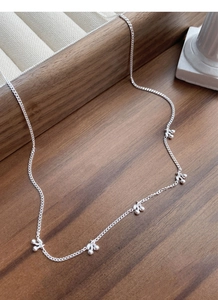Detail of S925 sterling silver necklace with multiple cherry pendants on wooden tray