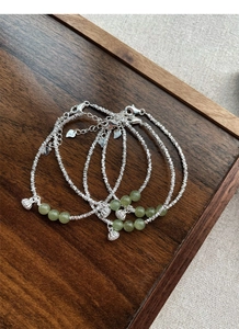 Detail of silver chain with S925 stamp, lotus pod charm and green jadeite beads