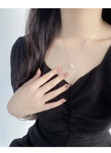 Détail du pendentif nœud en argent S925 avec perle sur un mannequin en robe