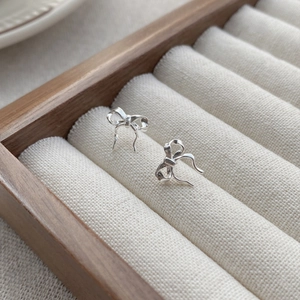 S925 sterling silver ribbon bow stud earrings with polished finish in a jewelry box
