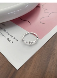 Close-up of S925 sterling silver heart ring with clear zircon on a decorative card