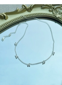 Detail of silver cherry necklace reflecting on mirror with vintage frame background