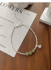Detailed macro view of S925 silver bracelet featuring lotus pendant and green jade beads