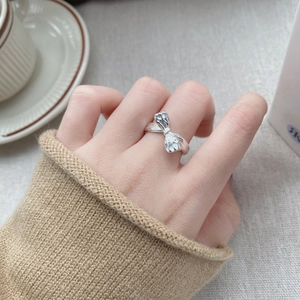 Minimalist S925 sterling silver bow knot open ring worn in a cozy lifestyle setting