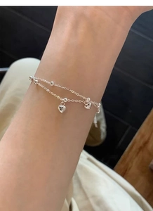 Close-up of a double-layered S925 sterling silver heart bracelet worn on a female wrist