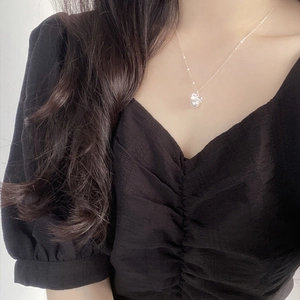 Collier chic en argent 925 avec nœud et perle sur un mannequin portant un haut noir