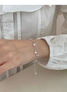 Close-up of S925 sterling silver double-layer bracelet with heart and bead charms