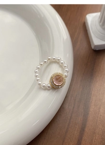 Detail of S925 silver pearl ring with pink gemstone on elegant ceramic plate