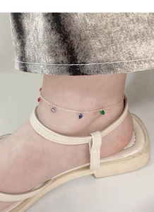 Détail de la chevillère en argent S925 avec zircons colorés portée sur la cheville