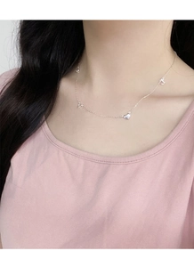 Detail of silver S925 necklace featuring LOVE letters and a heart pendant on model