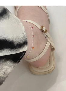 Gros plan d'une chevillère en argent S925 avec des perles de zircon colorées au pied