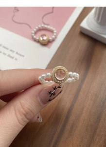 Macro shot of S925 silver pearl stretch ring featuring pink gem and crystal halo