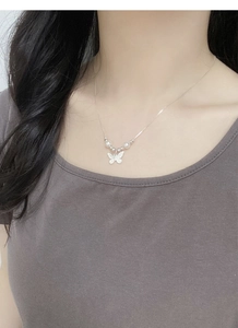 Silver butterfly necklace with pearls worn on neck showing elegant collarbone length