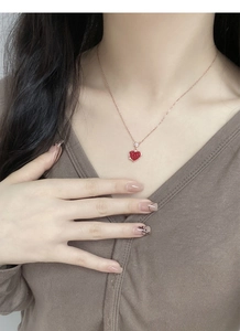 Gros plan du collier en argent S925 avec pendentif cœur rouge sur chaîne or rose