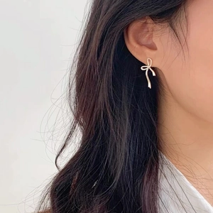 Eleganti orecchini a fiocco in argento sterling S925 indossati da una modella di profilo