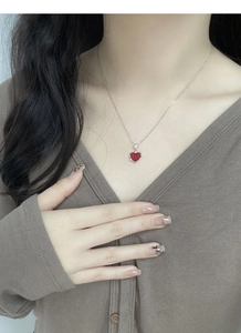 Gros plan du collier avec pendentif cœur rouge en argent S925 porté par un mannequin