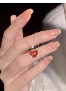 Gros plan d'un pendentif cœur en argent S925 avec petit diamant et chaîne en or rose