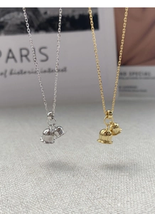Detailed close-up of lily of the valley pendants in polished silver and gold finishes
