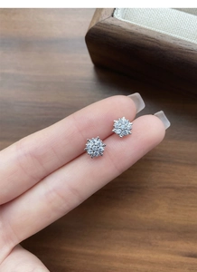 Detailed macro shot of sparkling S925 sterling silver snowflake stud earrings with crystals