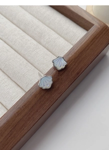 Macro view of shell stud earrings with iridescent luster and silver hardware details