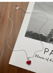 Détail macro du pendentif cœur rouge avec chaîne en argent S925 sur fond artistique