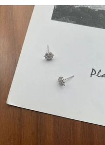 Detailed close-up of sparkling S925 sterling silver snowflake earrings on a card