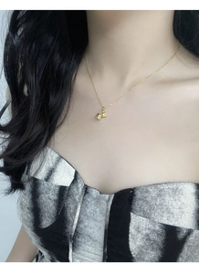 Detail of S925 silver lily of the valley pendant necklace worn on a woman's collarbone
