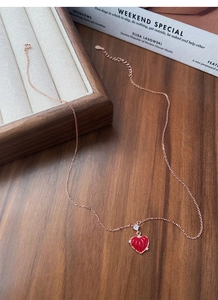 Détail du pendentif cœur rouge avec motifs radiaux et zircon sur chaîne en or rose