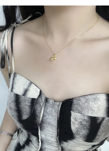 Close-up of S925 silver lily of the valley necklace on model neck in elegant gold finish