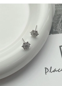 Macro view of S925 sterling silver snowflake stud earrings set with clear zircon stones
