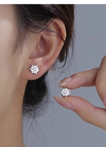 Detailed macro shot of S925 sterling silver snowflake stud earrings with sparkling stones