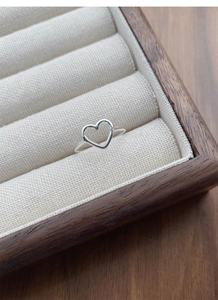 Macro shot of a minimalist hollow heart S925 silver ring on a jewelry display tray