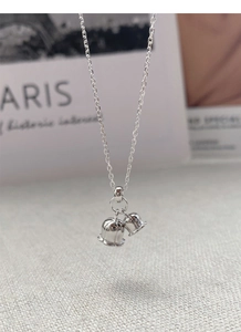 Macro detail of S925 sterling silver twin bell pendant on elegant O-chain necklace