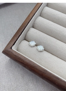 Macro view of shell stud earrings with white mother-of-pearl and silver metal edges